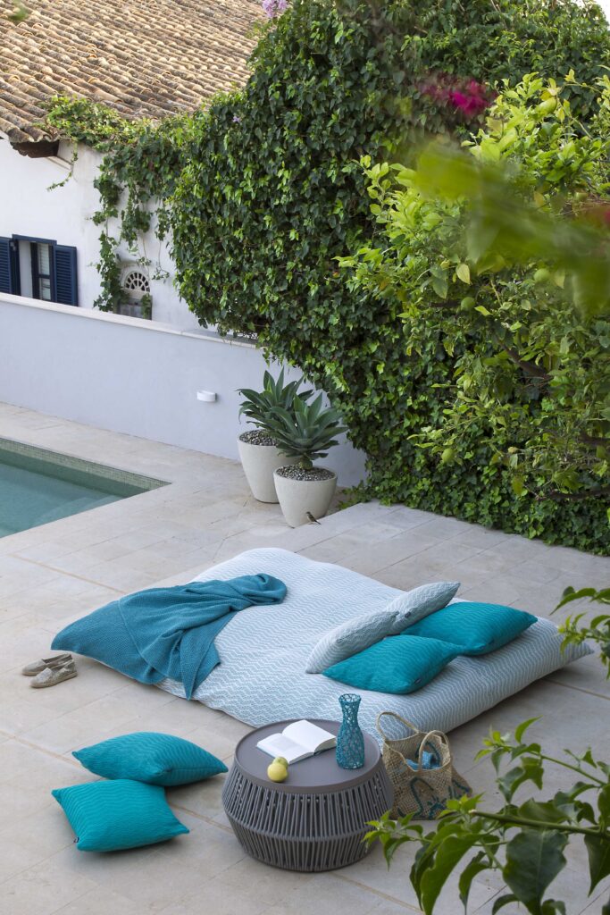 Modern outdoor sunbed that sits poolside in turquoise